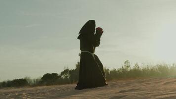 silhueta do a atleta monge faz boxe em a areia duna video