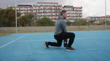 Mens doet hurken lunges stabiliteit opdrachten in de veld- naar trein quadriceps video