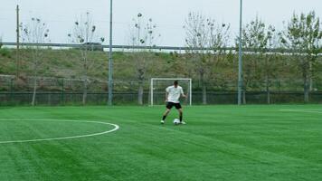 adolescenziale calcio giocatore corre con palla lungo il calcio campo video