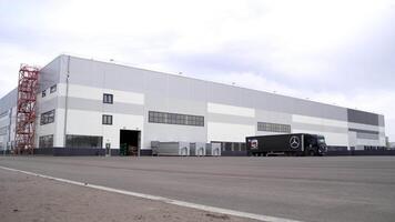 Oclo - Norway, 11.20.2021. new mercedes benz ware house with a parked truck. Scene. Large cargo car standing by a new building on cloudy sky background. video