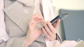 Woman is sitting and looking at phone. Action. Close-up of beautiful woman sitting on phone. Woman smiling is sitting on phone on clear sunny day video