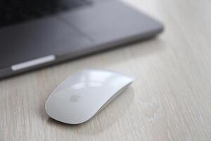 KYIV, UKRAINE - NOVEMBER 27, 2023 Apple Magic Mouse 3rd generation lies with grey MacBook 2021 photo