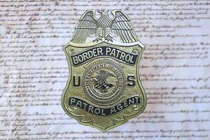 KYIV, UKRAINE - MARCH 9, 2024 US Border Patrol Agent badge on United States Constitution photo