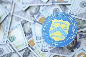 KYIV, UKRAINE - MARCH 9, 2024 US The Department of the Treasury seal on many US hundred dollar bills photo