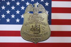 KYIV, UKRAINE - MARCH 9, 2024 US FBI Federal Bureau of Investigation badge on United States of America flag photo