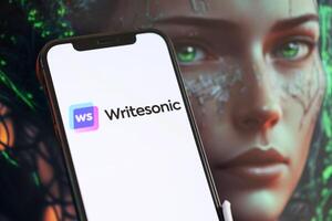 KYIV, UKRAINE - MARCH 17, 2024 Writesonic logo on iPhone display screen with background of artificial intelligence futuristic image photo