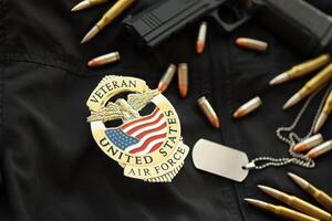 KYIV, UKRAINE - MARCH 9, 2024 US Air Force Veteran badge on black jacket uniform with gun, bullets and dogtags photo