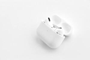 KYIV, UKRAINE - 4 MAY, 2023 Apple AirPods Pro on a white background. Wireless headphones in a charging case photo