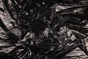 Texture of black plastic garbage disposable bag photo