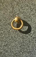 Metal ring on grave of cemetery. Rusty iron handle on granite tomb cover. An 19th century antique cemetery in Lviv photo