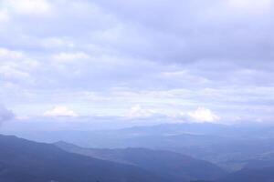 Morning view from the Dragobrat mountain peaks in Carpathian mountains, Ukraine. Cloudy and foggy landscape around Drahobrat Peaks photo