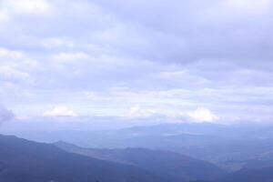 Morning view from the Dragobrat mountain peaks in Carpathian mountains, Ukraine. Cloudy and foggy landscape around Drahobrat Peaks photo