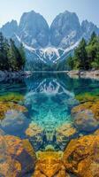 Lake Surrounded by Rocks and Trees With Mountains in Background photo