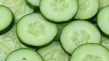 Cucumber slices top view, rotation. Background of chopped cucumber slices for cooking show, restaurant, cafe, fast food video