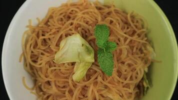 Bihun goreng, fried bee hoon, mee hoon, or rice vermicelli with vegetables and chili. A food with delicious, spicy and sweet taste on rotating display video