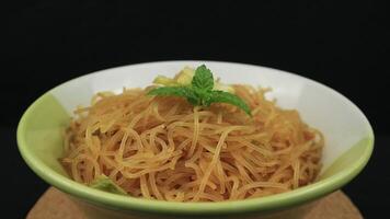 bihun goreng, gebakken bij hoon, mee hoon, of rijst- vermicelli met groenten en Chili. een voedsel met verrukkelijk, pittig en zoet smaak Aan roterend Scherm video