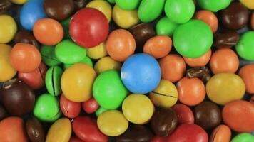 Candy sweets background. Assorted colorful chocolate candies. Colorful delicious sweets turning top view. video