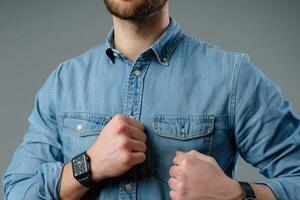 AI generated Young businessman in denim shirt with smartwatch on gray background. photo