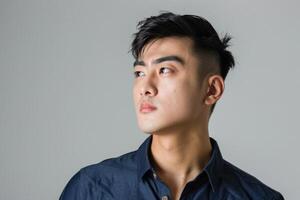 AI generated Portrait of young Asian man in blue shirt  looking away photo