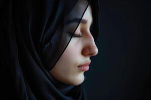 AI generated A Muslim woman with closed eyes  on a black background. Arab girl in hijab in profile. photo