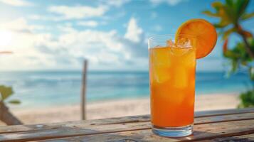 Fresh orange cocktail on wooden table. Blur beach on background photo