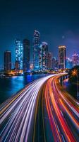 Streaks of moving car lights against the backdrop of city lights at night photo