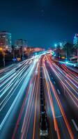 Streaks of moving car lights against the backdrop of city lights at night photo