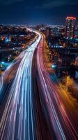 Streaks of moving car lights against the backdrop of city lights at night photo