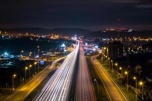 Streaks of moving car lights against the backdrop of city lights at night photo