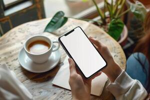 manos participación teléfono con blanco Bosquejo pantalla en contra café mesa fondo foto