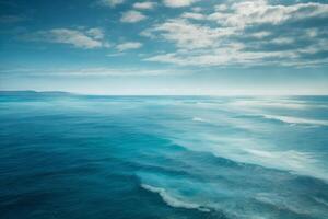 a beautiful blue ocean with waves and clouds photo