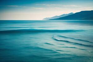 a beautiful blue ocean with waves and clouds photo