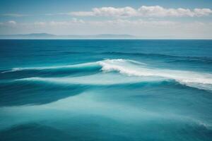 a beautiful blue ocean with waves and clouds photo