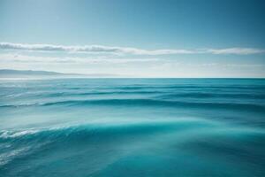 a beautiful blue ocean with waves and clouds photo