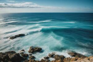 blue ocean with mountains and clouds photo