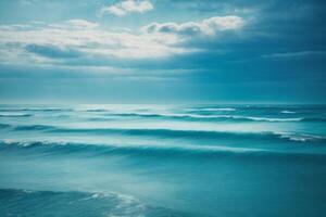 blue ocean with clouds and sun in the sky photo