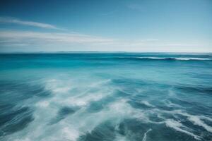 a beautiful beach with waves and blue sky photo