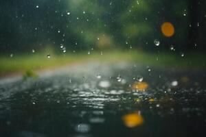 raindrops on the ground with lights in the background photo