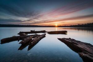 un lago con arboles y un brumoso cielo a puesta de sol foto