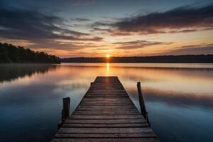 a pier on a lake at sunset photo