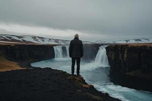 hombre en pie en el borde de un cascada mirando a el Oceano foto