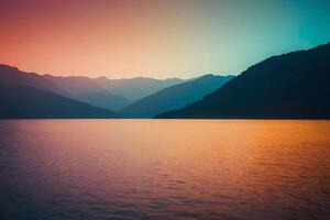 a sunset over the water with mountains in the background photo