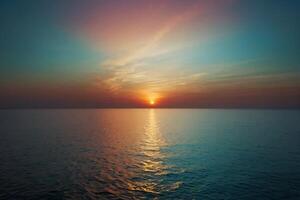 the sun setting over the ocean in a tropical beach photo