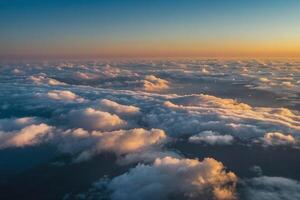 the sun is setting over the clouds as seen from an airplane photo