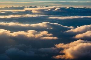 the sun is setting over the clouds as seen from an airplane photo