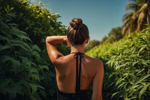 un mujer en un uno pedazo traje de baño soportes en el playa a puesta de sol foto