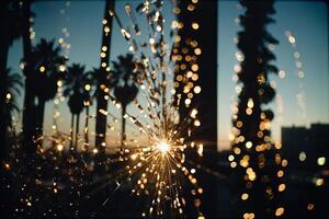 a sparkler is shining in the dark with palm trees in the background photo