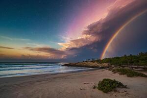 a colorful stormy sky over the ocean and sand photo