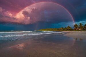 a rainbow over the ocean at night photo