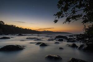 ai generado un largo exposición fotografía de el Oceano a puesta de sol foto
